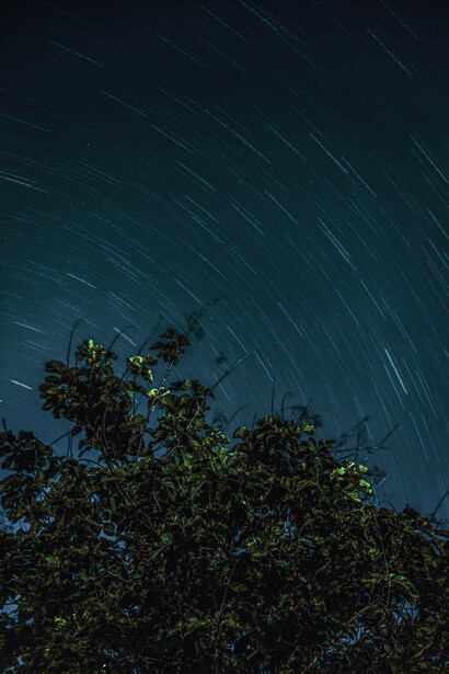 Long star trail photograph over Lake George, NY, capturing the beauty of the night sky, galaxies, and celestial movement