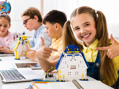 Curious students present their robotic projects during a hands-on technology workshop in a modern classroom setting