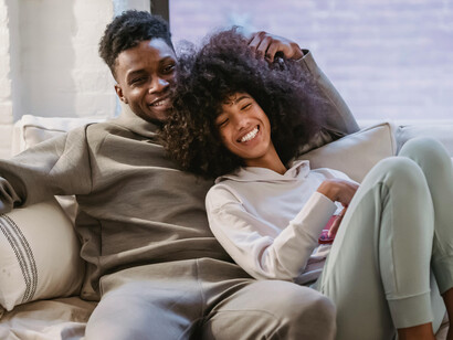 A smiling young couple enjoys a peaceful moment together on the sofa, creating a warm and welcoming atmosphere at home