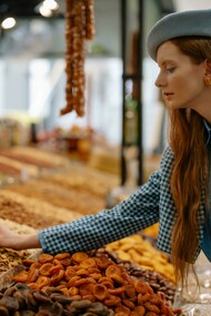 A woman buying seeds and nuts at the market for a healthy lifestyle
