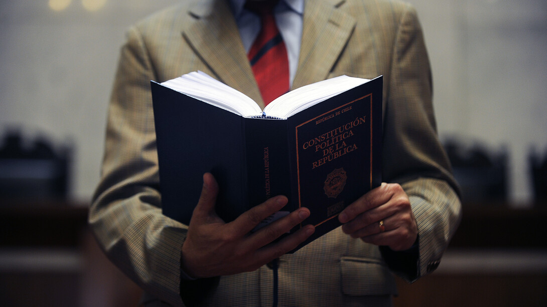 Un hombre leyendo la Constitución chilena