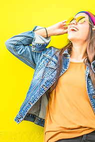 A woman is smiling in front of a yellow wall