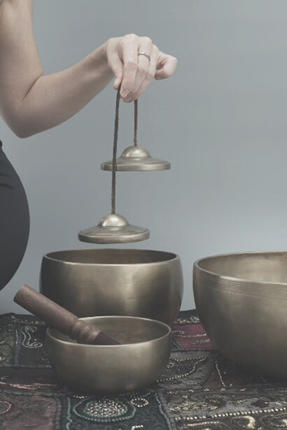 A person gracefully holding a sleek brown wooden round container with a firm grip