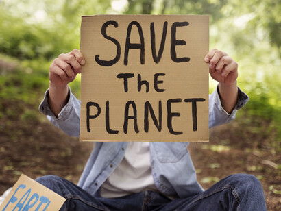 Giovane attivista sui temi ambientali con il cartello "Save the planet"  (Salviamo il pianeta) 