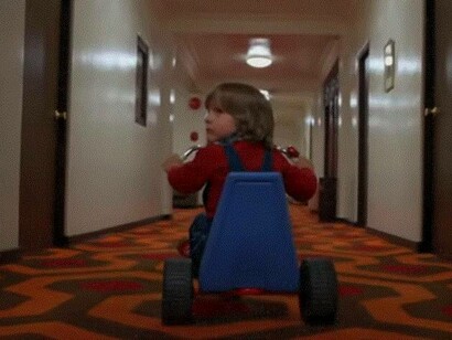 Danny Torrance nel film "Shining" di Stanley Kubrick durante una famosa scena con il triciclo