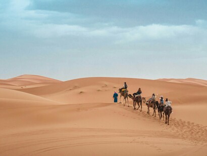 Tourists ride camels through the Agafay Desert before beginning their hike in the Atlas Mountains