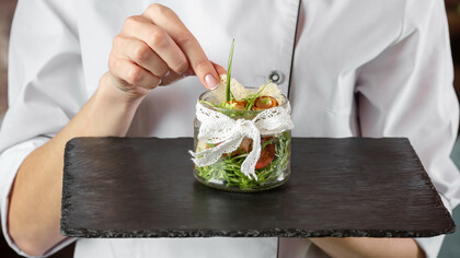 A chef presenting an enticing dish, showcasing current culinary trends