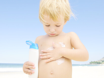 Un niño aplicándose protección solar