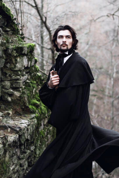 A young man wearing a Victorian-era suit is standing