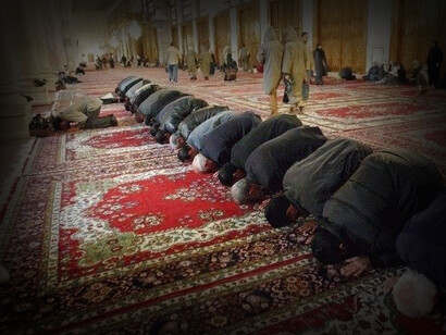 Hombres de cara a La Meca se reúnen para rezar, a la hora del almuerzo, en la mezquita omeya, la más importante de Siria