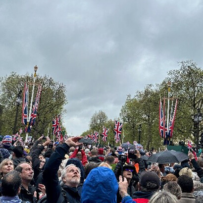 People on the street of coronation day in front of Buckingham Palace, London England