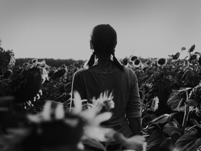 Joven de espaldas en medio de flores