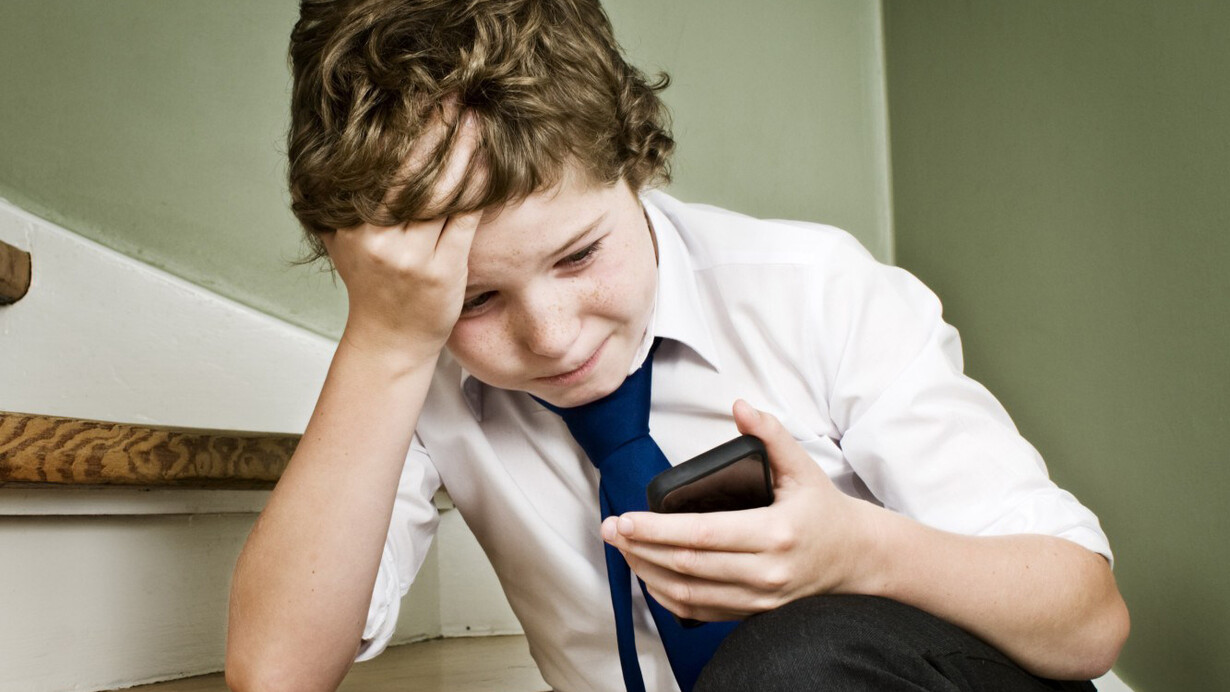 La era digital. Un niño dedica toda su atención a un teléfono móvil