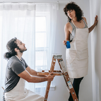 Amigos dialogam sobre textura da tinta no parede que pintaram 
