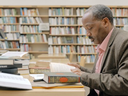 Professor consulta livros na biblioteca