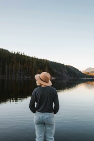 Person connecting with nature by standing in front of a lake to find a mental peace