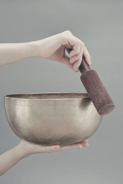 A person gently holding a beautifully glazed brown clay pot, resonating with the energy of solfeggio frequencies and the healing power of sound