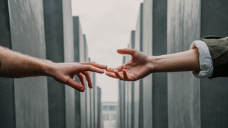 Two hands extended toward each other in a gesture of assistance and support