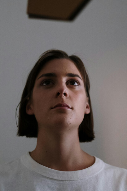 With her eyes cast toward the horizon, she embodies the essence of seeking meaning beyond the surface, a reminder that true storytelling requires vulnerability and honesty
