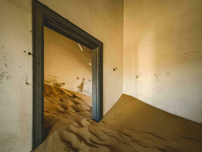 Sand spilling through open doors representing the merging of dreams and time