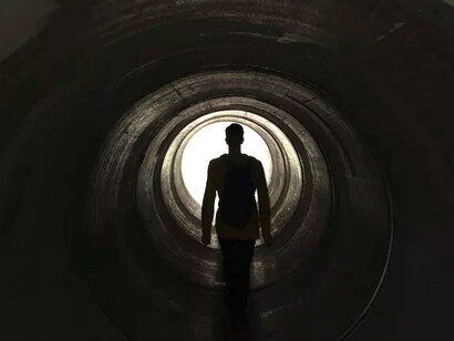 Hombre frente a la salida de un túnel