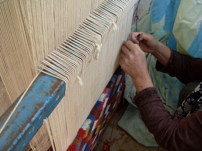 Hiladora mostrando la estructura de alfombra iraní