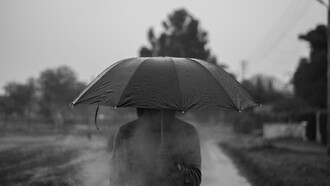 Homem anda sozinho pela chuva