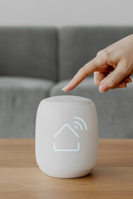 A fingertip activates a smart home hub — symbolizing the connectivity and control of IoT innovation 