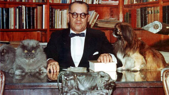 João Guimarães Rosa em sua biblioteca particular junto aos seus gatos e cachorro