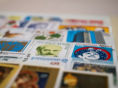A close-up of a collection of stamps on a table, featuring Soviet-era memorabilia and childhood souvenirs from the Soviet Union