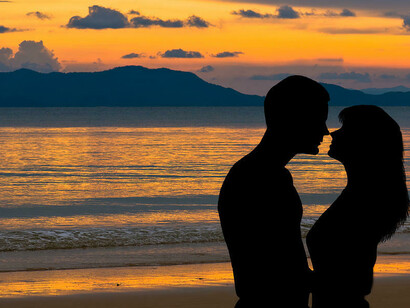 Pareja acaramelada en la orilla del mar