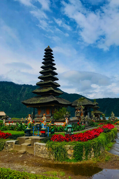 A serene lake in Bali, Indonesia, with a pagoda in the background