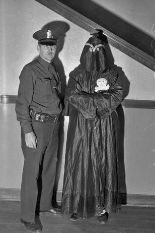 Police officer stands with R.F. McGarry, member of the Black Legion secret society