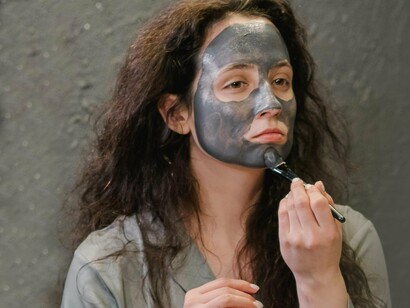 Mulher aplicando máscara de tratamento no rosto. Há algo que acontece quando atingimos essa marca: o corpo, já não mais tão firme, começa a dar sinais de que o tempo não passa em vão

