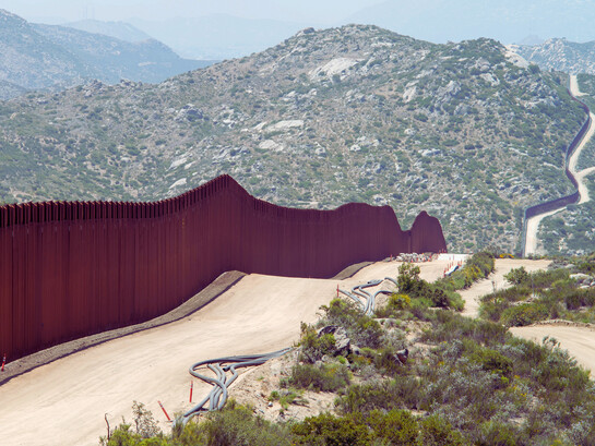 The USA–Mexico border wall in Southern California, cutting through the mountains