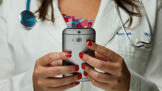 Envision a nurse gracefully holding a mobile phone in the image