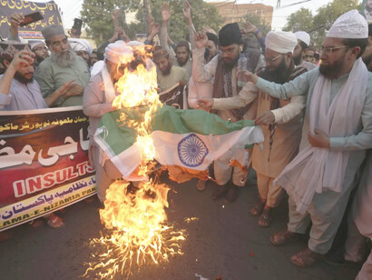 Partidarios de grupos religiosos queman una bandera india durante una manifestación en contra de Nupur Sharma, portavoz del gobernante partido nacionalista hindú. Lahore, Pakistán, 9 de junio de 2022