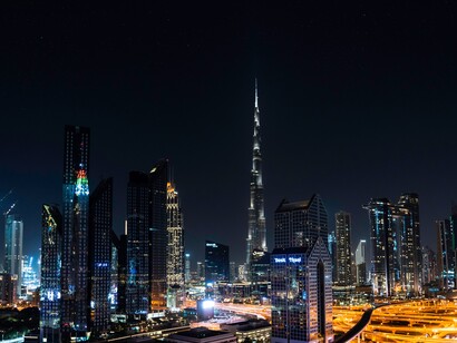 A city landscape at night. Businesses are defined by what they sell