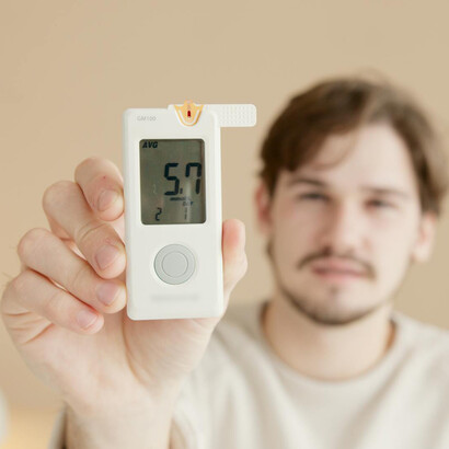 Hombre muestra el resultado de la medición de su glucosa en sangre