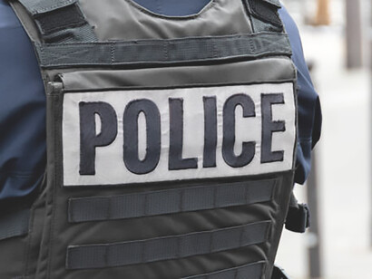 Close-up 'Police' marking written on the back of a bulletproof vest worn by a French police officer, France