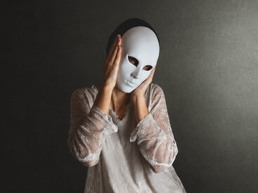 As a woman lifts one mask away, another remains underneath, representing the hidden self concealed beneath social roles, expectations, and appearances