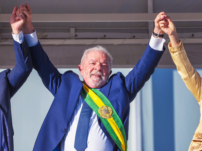 Luiz Inácio Lula da Silva greets supporters from the steps of The Palácio do Planalto in Brasília, Brazil, underscoring his commitment to social programs like Bolsa Família that aim to combat poverty and inequality