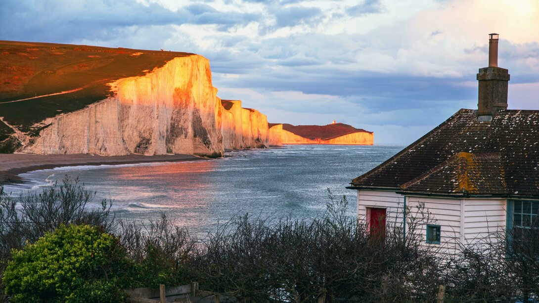 The Seven Sisters Cliffs glowing at sunset by the sea, United Kingdom