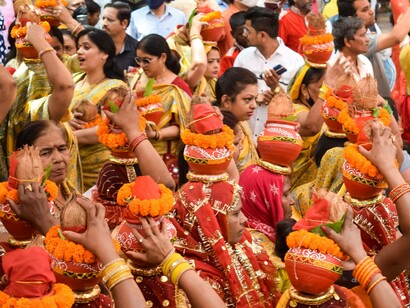 Women holding kalash on their heads during a festival in India