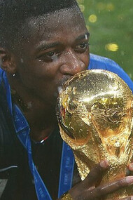 Le footballeur français Ousmane Dembélé, lauréat du Ballon d'or 2025, brandissant le trophée de la Coupe du monde de la FIFA après la finale du tournoi, le 15 juillet 2018