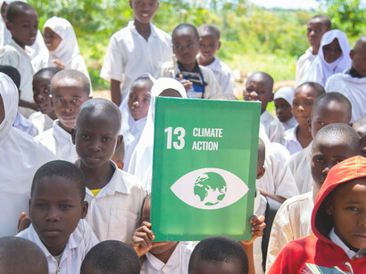 Children advocating for climate action in an outdoor setting as part of a sustainable community development initiative in a rural area