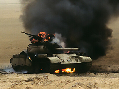 An Iraqi Type 69 main battle tank burns after being struck by the 1st United Kingdom Armoured Division during Operation Desert Storm