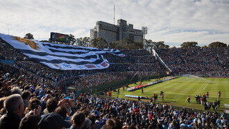 Una bandera gigante de Uruguay cubre las gradas durante un partido de la Selección de fútbol uruguaya, oficiando como local en el estadio Centenario. 2 de junio de 2012, Montevideo, Uruguay