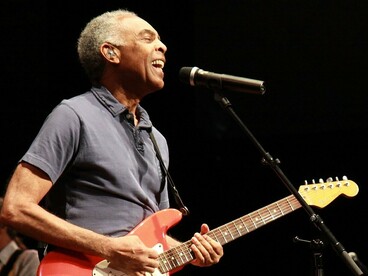 Gilberto Gil canta e toca guitarra durante apresentação no Festival de Cornouaille, em Quimper, na França, em 2010. Entre o sorriso e a música, o palco registra um dos muitos momentos em que o artista se tornou presença constante na memória afetiva de diferentes gerações