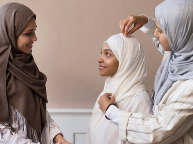 Three hijabi women united in mutual support and empowerment